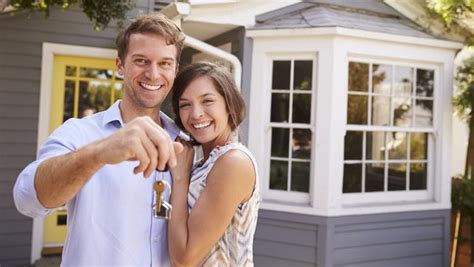 Smiling couple owning keys to new home